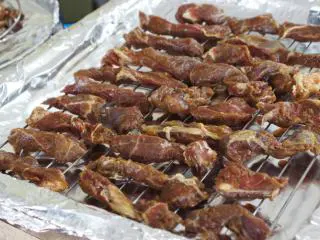 八珍盛宴：过年少不了的零食风味牛肉干 ,烤盘上铺锡纸。放上烤架，将牛肉摆放在烤架上