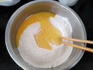 #地方特色小吃# 自制龙抄手,面粉中加入盐,鸡蛋打散倒入盆里,拌匀