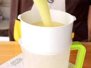 米香玉米汁(豆浆机版),打好的玉米汁倒入过筛网 tips:这里是为了去除玉米皮衣的,玉米皮衣对于小月龄的宝宝来说不好消化,所以过筛掉即可