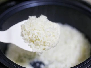 红烧豆腐盖饭,这时大米饭煮好了。用这款锅煮出来的米饭粒粒分明，口感新鲜，保留原有营养，好吃还不用担心长胖。盛一碗放入盘中。