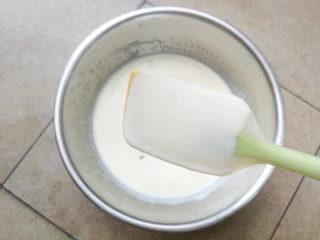 巧克力双色雪糕,奶糊离火晾凉,晾凉过程中需不时搅拌奶糊,以免表面结成奶皮,晾凉的奶糊用滤网过筛两遍,使奶糊质地更加细腻