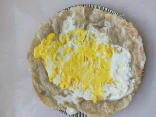 街头手抓饼的吃法----懒人必备早餐,煎至鸡蛋熟透,手抓饼也变金黄,关火,盛出装盘