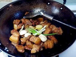 虎皮鹌鹑蛋红烧肉,倒入料酒、生抽、老抽，把准备好的葱姜蒜等香料一起放进去继续翻炒