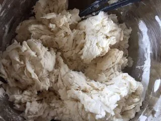 简易版陕西小吃烩麻食,加入冷水筷子搅拌,每个面粉的吸水性不同,自行添加,面要和的硬一些,这样麻食的形状漂亮,口感更有劲道