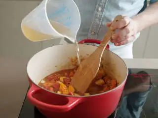 土耳其风味红扁豆汤,倒入蔬菜高汤，微沸15分钟，或直至红扁豆熟透。