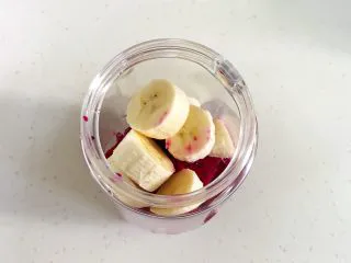 火龙果香蕉奶昔,香蕉切皮,切块放入。