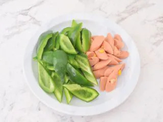 青椒火腿肠炒鸡蛋,火腿肠去除外包装切片,青椒去籽洗净切成小块
