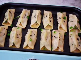 猪肉韭菜锅贴,撒上黑芝麻即可