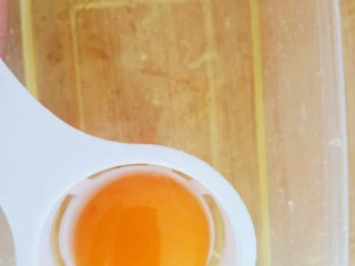 皮蛋特色小吃,三个鸡蛋用分蛋器分离,蛋清放到盒子里。