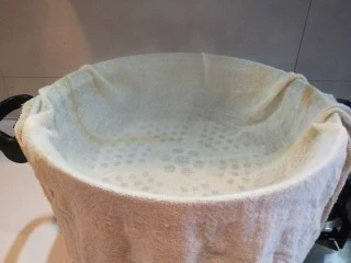 新文美食 北京特色小吃蒸年糕,我用大一点的蒸锅,加入半锅水,铺上屉布,把水烧开。