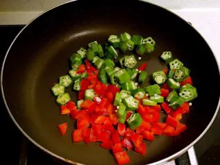 风味独特的 杂蔬炒珍珠丸子,在锅里加入彩椒丁和秋葵片，翻炒1分钟