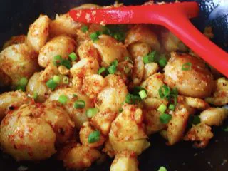 烧烤风味的香煎孜然小土豆,把加了烧烤口味的调料和辣椒面用锅铲轻轻翻拌均匀后，再稍微煎制一会，为的是让土豆把调料味入进去，看见调料全部融入土豆里面后，关火后，再撒上小香葱花就可以出锅咯；
