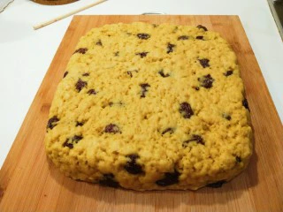 新文美食 北京特色小吃蒸年糕,蒸好直接提屉布拿出放在案板,手沾水压实,放凉切成四块。