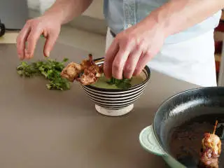 亚洲风味西兰花汤,将汤倒入碗中，饰以鸡肉串、香菜，撒上黑白芝麻。尽情享用吧！