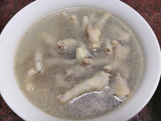 美味小吃,老坛酸辣鸡爪,熟了马上捞起倒在准备好的冰水里。这个步骤是为了收缩煮软的肉,使得鸡爪口感更Q弹。