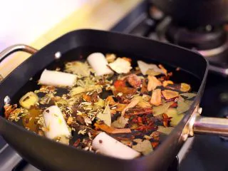 陕西小吃—肉夹馍,倒入2500克的水,下事先切好的大葱与姜片及各种香料,在倒入80克料酒。