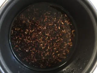 芒果黑米椰奶西米露,黑糯米加入白糖电饭锅里煮熟。