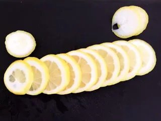 蜜渍柠檬皇菊茶,把柠檬切成6㎜厚的薄片，两头切掉不要