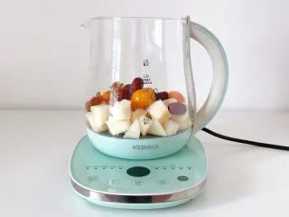 冰糖雪梨金桔饮,往康佳养生壶内加入雪梨、金桔、红枣和冰糖。