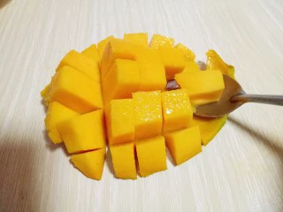 #冬喝暖饮夏吃冰#健康低卡-芒果酸奶昔,再用勺子将芒果肉挖下来。