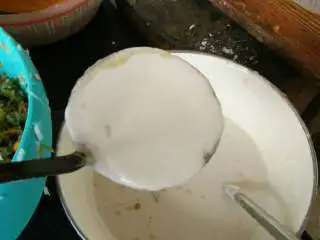 松阳特色小吃灯盏盘,趁滚烫的温度，将一勺米糊均匀的浇在，灯盏盘的底座上，薄薄的一层就够了。