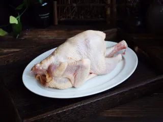 百变水果 新奥尔良风味雪梨烤鸡,首先将三黄鸡的内脏清理干净，剁去鸡爪子和鸡脖子。