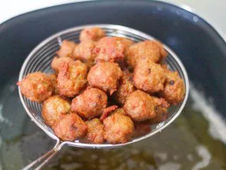 老北京小吃之“干炸小丸子”,第二遍油温100度左右的时候再炸,炸至丸子表面微微变硬就好了,捞出来控油。