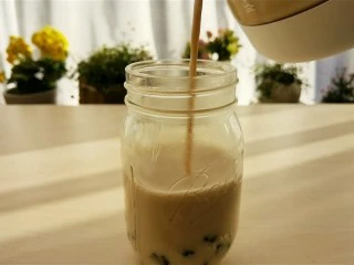 宅家自制珍珠奶茶,最后把煮好的奶茶倒入杯里，加入珍珠。
