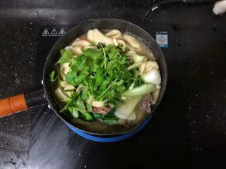 河南小吃-羊肉烩面,20、最后撒上香菜段和蒜苗粒,淋上少许香油即可。
