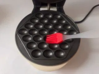 香港名小吃鸡蛋仔,在烤盘上刷一层油,插电预热1分钟