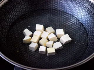 丝瓜花蛤炖豆腐,锅中倒入适量的清水，加入少许盐，把豆腐进行焯水，焯一分钟左右即可捞出沥干水分。