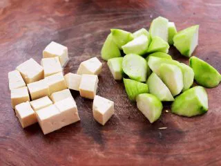 丝瓜花蛤炖豆腐,丝瓜去皮后切成滚刀块，豆腐切小方块。