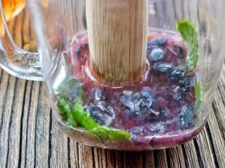 蓝莓Mojito鸡尾酒,用小棍压破蓝莓，挤压出水份