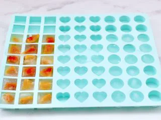 黄桃养乐多冰咖啡,把切块的黄桃一半放入冰格里，加入纯净水后放入冰柜里冷冻成冰块。