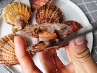 蒜蓉粉丝蒸扇贝,再用小刀将扇贝肉与壳分离。