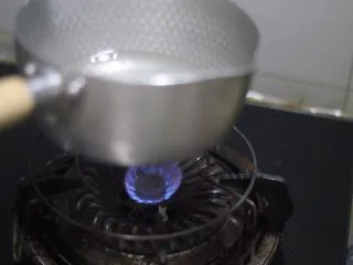 老北京小吃之冰糖葫芦,改小火,锅离火苗3cm左右晃动锅子,帮助小块冰糖溶解。