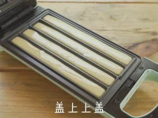 西班牙小吃get |国庆在家做吉事果,轻食机安装好油条盘，预热完成后，挤入面糊。盖上上盖，翻转轻食机。