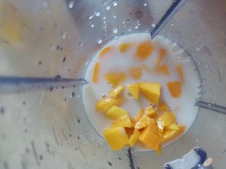 夏日甜品杨枝甘露,芒果丁放入料理机，加入牛奶
