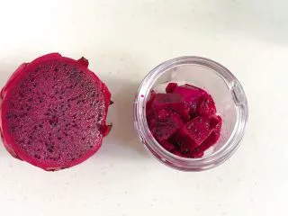 火龙果香蕉奶昔,取半个火龙果切块,放入搅拌杯内。