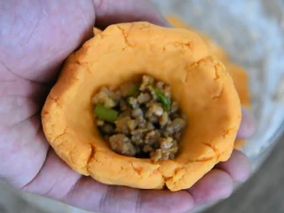 福清番薯丸这么经典的小吃你会做吗?,抓取适量的面皮,用手摊成碗状加入各种馅料,包圆