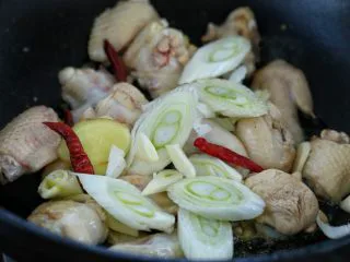 鸡翅腐竹烧土豆,然后放入葱花、姜片、蒜片和红干椒,翻炒出香味