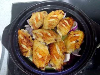 新奥尔良风味砂锅翅,直接把鸡翅从煎锅逐只摆入砂锅，往腌鸡翅的盘子里倒小半碗清水，搅匀盘子里剩下的调料，倒入砂锅，补一勺生抽，盖好盖子，小火煮10分钟。