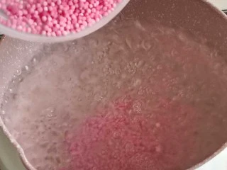 缤纷水果西米露,起锅烧水,水开后倒入粉色草莓味西米,中到大火煮15分钟。普通白色的西米也可以