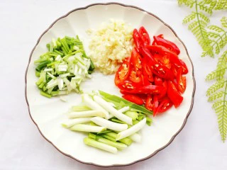 拿肉都不换的素炒香菇,小葱切断,青红椒斜刀切,大蒜切丁放入盘中备用,香菇切片。
