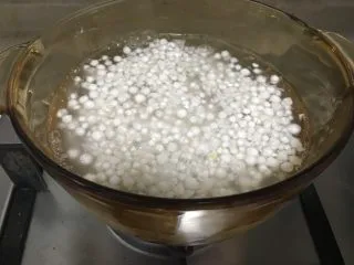 芒果黑米椰奶西米露,大火煮开西米露后转小火煮熟。