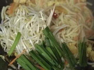 云南风味炒米线,翻炒均匀后加入豆芽菜和韭菜