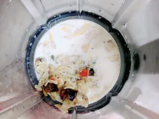 芒果麦片坚果露,将牛奶麦片倒入破壁机中。