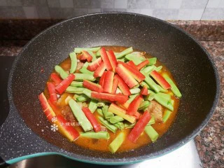 四季豆烧排骨,放入四季豆和胡萝卜翻炒均匀。