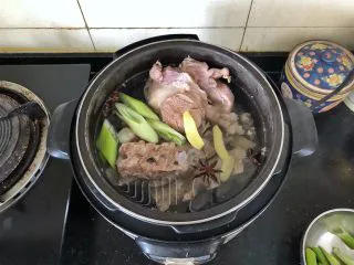 河南小吃-羊肉烩面,5、放入葱段、姜片、花椒、八角、料酒,盖好盖子压30分钟。