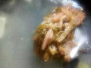 酸香风味鱼头锅,烧沸后加入炒香的酸青菜丝继续熬制。